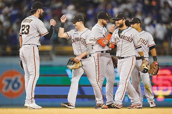 Giants first baseman Kris Bryant (left) is greeted by teammates after Monday night's 1-0 win against the Dodgers in Los Angeles.