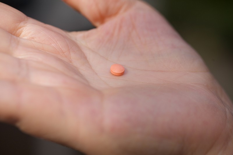 A woman holds an aspirin pill in the Brooklyn borough of New York on Friday, Oct. 15, 2021. According to the U.S. Preventive Services Task Force's preliminary updated advice released on Tuesday, Oct. 12, 2021, older adults without heart disease shouldn't take daily aspirin to prevent a first heart attack or stroke. (AP Photo/Emma H. Tobin)