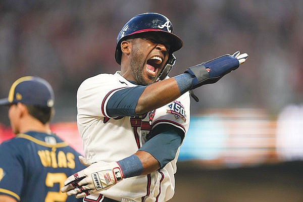 Guillermo Heredia of the Braves celebrates an RBI single hit by teammate Eddie Rosario during Tuesday's game against the Brewers in Atlanta.