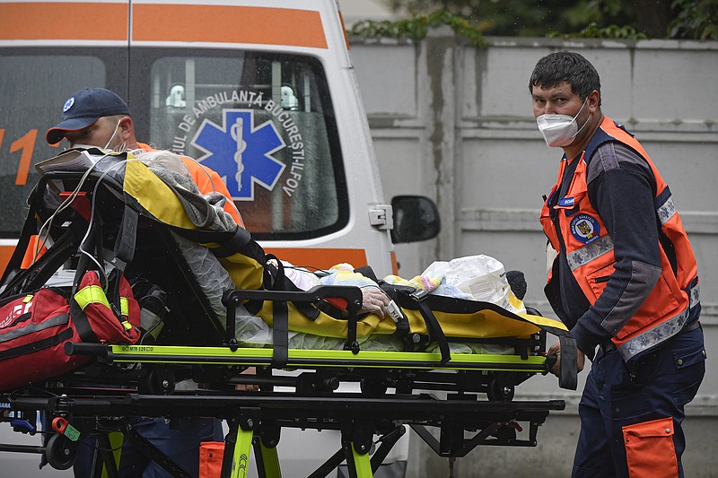 Paramedics bring an elderly patient to the emergency room, turned into a CODIV-19 unit due the high number of cases, at the Bagdasar-Arseni hospital in Bucharest, Romania, Tuesday, Oct. 12, 2021. Romania reported on Tuesday nearly 17,000 new COVID-19 infections and 442 deaths, the highest number of coronavirus infections and deaths in a day since the pandemic started, as the nation's health care system struggles to cope with an acute surge of new cases.(AP Photo/Andreea Alexandru)