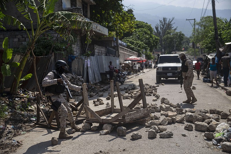 Police remove a roadblock set by protesters in Port-au-Prince, Haiti, Monday, Oct. 18, 2021. Workers angry about the nation’s lack of security went on strike in protest two days after 17 members of a U.S.-based missionary group were abducted by a violent gang. (AP Photo/Joseph Odelyn)