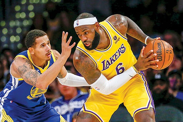 LeBron James of the Lakers is defended by Juan Toscano-Anderson of the Warriors during a preseason game earlier this month in Los Angeles.