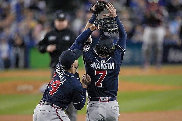 Braves teammates Adam Duvall and Dansby Swanson come together to catch a fly ball by Corey Seager of the Dodgers during Wednesday night's game in Los Angeles. Swanson caught the ball for the out.