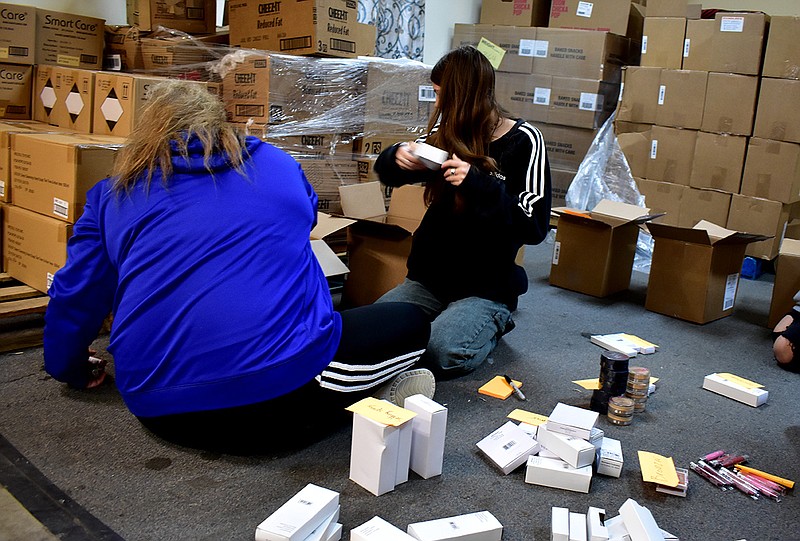 News Tribune/Elise EakerMariah Coleman, left, and Hattie Rogers sort through makeup Thursday at SERVE during South Callaway High School's day of service. 