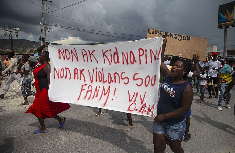 People protest carrying a banner with a message that reads in Creole: "No to kidnappings, no to violence against women ! Long live Christian Aid Ministries,"  demanding the release of kidnapped missionaries, in Titanyen, north of Port-au-Prince, Haiti, Tuesday, Oct. 19, 2021. A group of 17 U.S. missionaries including children was kidnapped by a gang in Haiti on Oct. 16. (AP Photo/Joseph Odelyn)