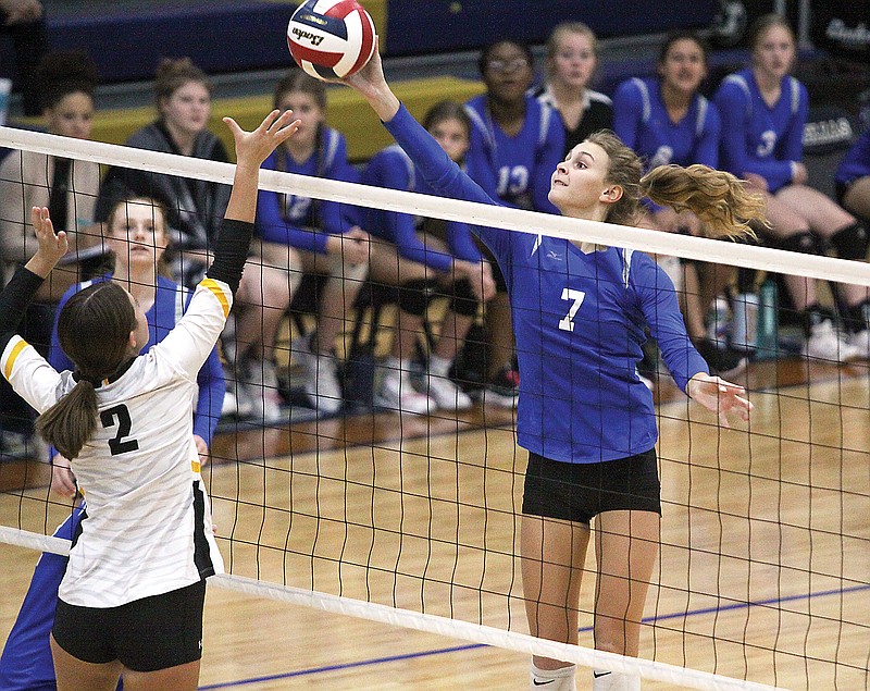 Capital City middle hitter Ava Meinhardt tries to hit the ball out of reach of Sedalia Smith-Cotton's Briara Jackson during Thursday's match in the Class 5 District 9 Tournament at Rackers Fieldhouse.