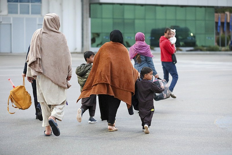 Inn this image provided by the U.S. Army, U.S.-affiliated Afghans arrive at the Pristina International Airport in Kosovo on Oct. 16, 2021. During their temporary stay at Camp Liya, Afghan families receive housing, medical, and logistical support from Task Force Ever Vigilant. The U.S. is welcoming tens of thousands of Afghans airlifted out of Kabul but has disclosed little publicly about a small group who remain overseas: Dozens who triggered potential security issues during security vetting and have been sent to an American base in the Balkan nation of Kosovo. The exact number in Kosovo fluctuates as new people arrive and others leave when security issues, such as missing documents, are resolved, according to U.S. officials. (Sgt. Gloria Kamencik/U.S. Army via AP)