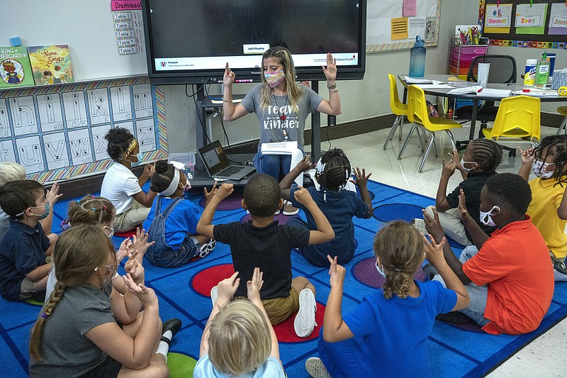 FILE - In this Friday, Aug. 20, 2021, file photo, kindergarten teacher Amber Updegrove interacts with her students at Warner Arts Magnet Elementary in Nashville, Tenn., in Davidson County. A Tennessee school district can continue requiring students to wear masks in school after a federal judge extended a ruling blocking an opt out provision. The Tennessean reports, the ruling, on Friday, Oct. 22, 2021, affects the Williamson County and Franklin school systems. (AP Photo/John Partipilo, File)