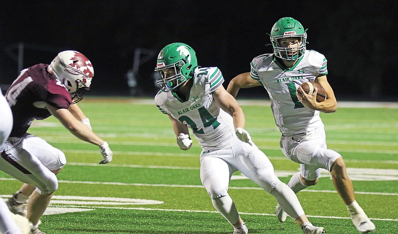 Blair Oaks running back Cadon Garber clears space for quarterback Dylan Hair to run Friday night in a game against School of the Osage in Osage Beach.
