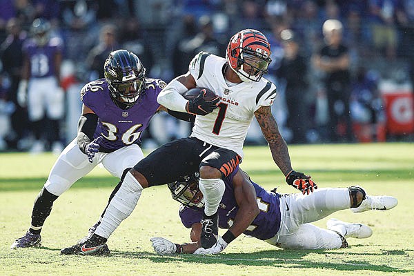 Ravens safety Chuck Clark (left) and cornerback Marlon Humphrey miss a tackle of Bengals wide receiver Ja'Marr Chase before he took off for a long touchdown after a reception during Sunday's game in Baltimore.