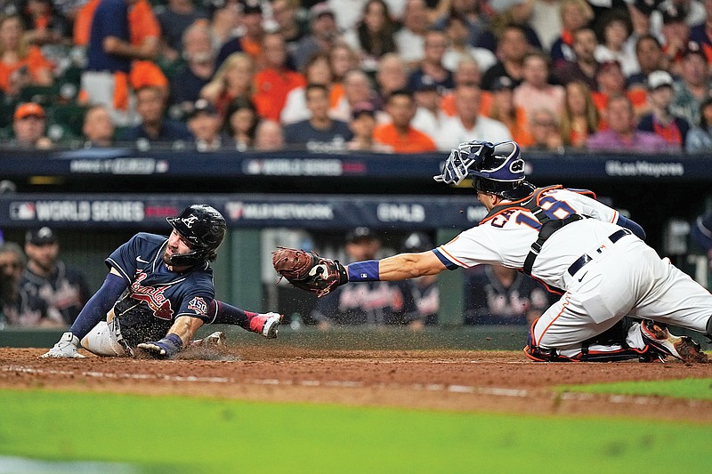 Dansby Swanson of the Braves scores past Astros catcher Jason Castro on a sacrifice fly during the eighth inning Tuesday in Game 1 of the World Series in Houston.