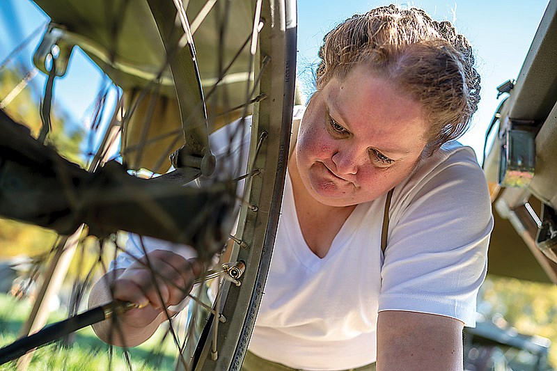 Melody Cook refills a cart's tire during the annual military history appreciation weekend on Saturday, November 6, 2021 at the Museum of Missouri Military History in Jefferson City, Mo. Cook used an original 1943 Airborne air compressor. (Ethan Weston/News Tribune photo)