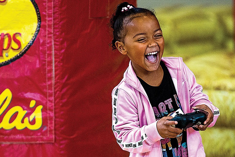 Jade Washington laughs as she runs an Radio Controlled car into some of the inflatable furniture at the Special Olympics Missouri's Outdoor Adventure event on Saturday, November, 13 at the Missouri Special Olympics' campus in Jefferson City, Mo. (Ethan Weston/News Tribune photo)