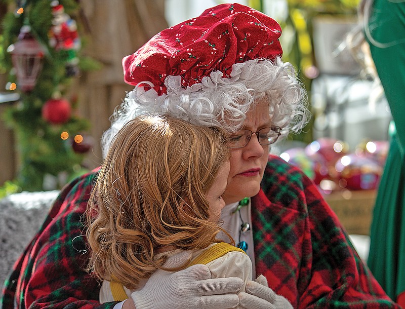 <p>Ethan Weston/News Tribune</p><p>Vera Kremer, 4, hugs Mrs. Claus on Saturday at Busch’s Florist and Greenhouse in Jefferson City. Kremer asked Santa for a “baby alive” toy.</p>