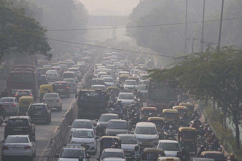 Commuters drive amidst morning haze and toxic smog in New Delhi, India, Wednesday, Nov. 17, 2021. Schools were closed indefinitely and some coal-based power plants shut down as the Indian capital and neighboring states invoked harsh measures Wednesday to combat air pollution after an order from the federal environment ministry panel. (AP Photo/Manish Swarup)