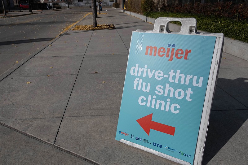 A sign directing traffic to a drive-through flu shot station is pictured at Comerica Park in downtown Detroit, Michigan, November 10, 2020. (Seth Herald/AFP/Getty Images/TNS)