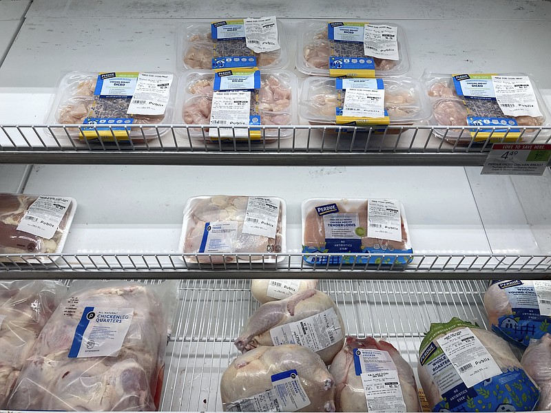 A near empty case of different chicken cuts is displayed at a Publix Supermarket, Wednesday, Oct. 20, 2021, in Miami.  A wide range of companies could feel a tighter squeeze on their profits from rising food prices if inflation keeps running hot. Grocery stores, restaurants and food producers have been able to pass along much of the impact from inflation to consumers, who have so far eaten most of the increase.  (AP Photo/Marta Lavandier, File)
