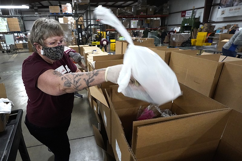 Volunteer Linda Nordin places a meat package into a box with other food at the Northern Illinois Food Bank to be delivered by DoorDash drivers for area residents who are homebound Wednesday, Nov. 10, 2021, in Park City, Ill. Previously, the pantry's express program was not available to its homebound clients because someone had to physically go to a collection point to pick up the food. But with DoorDash's technology, now homebound clients can go to the My Pantry Express website and pick from the available food. (AP Photo/Charles Rex Arbogast)