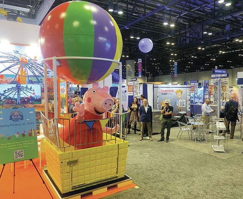 A costumed Peppa Pig character poses in a ride vehicle that will be part of the Peppa Pig Theme Park when it opens in Winter Haven in February 2022. The attraction shared details about its offerings during the IAAPA Expo at the Orange County Convention Center, on Tuesday, Nov. 16, 2021. (Dewayne Bevil/Orlando Sentinel/TNS)