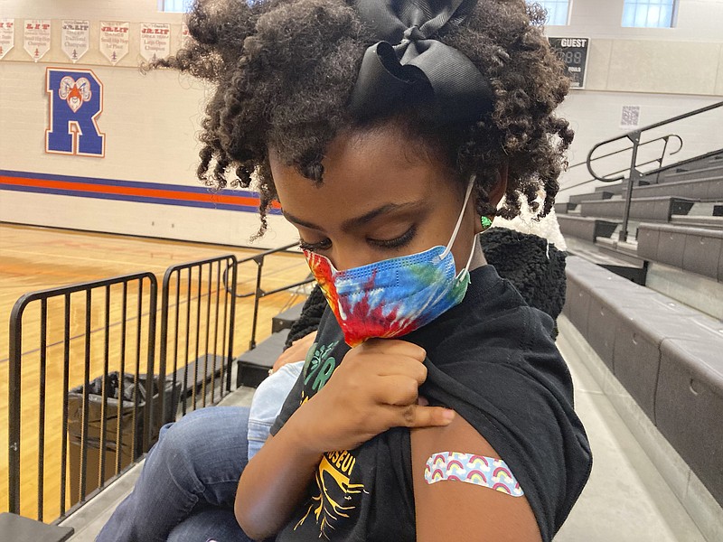 Solome Walker, 9, looks down at her bandage after getting her first Pfizer COVID-19 shot at a vaccination clinic for young students at Ramsey Middle School on Saturday, Nov. 13, 2021 in Louisville, Ky. Scientists say vaccinating kids against COVID-19 should not only slow the spread of the coronavirus but also help prevent potentially-dangerous variants from emerging. Each new infection brings another opportunity for the virus to mutate and evolve dangerous new traits. (AP Photo/Laura Ungar)