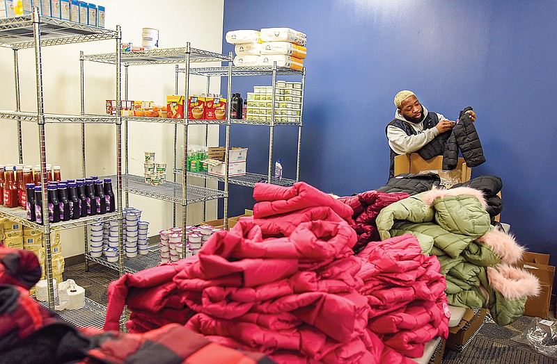 Julie Smith/News TribuneTerrance Brown II straightens out coats and jackets Tuesday in the Lincoln University Student Resource Center located in the basement of Scruggs Center. In addition to clothing, there is non-perishable food available for students to pick up.