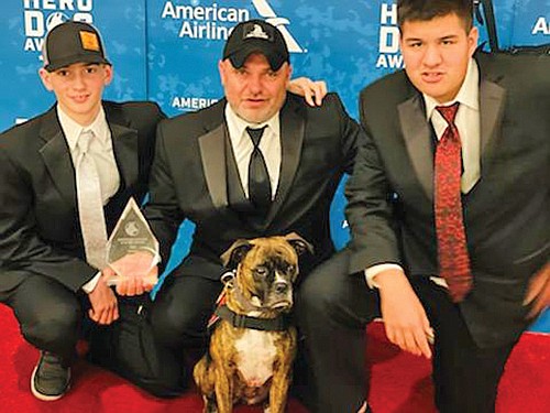 Jason Howe (center) poses with his two sons and Sobee, his service dog. Sobee was named the 2021 service dog of the year. 