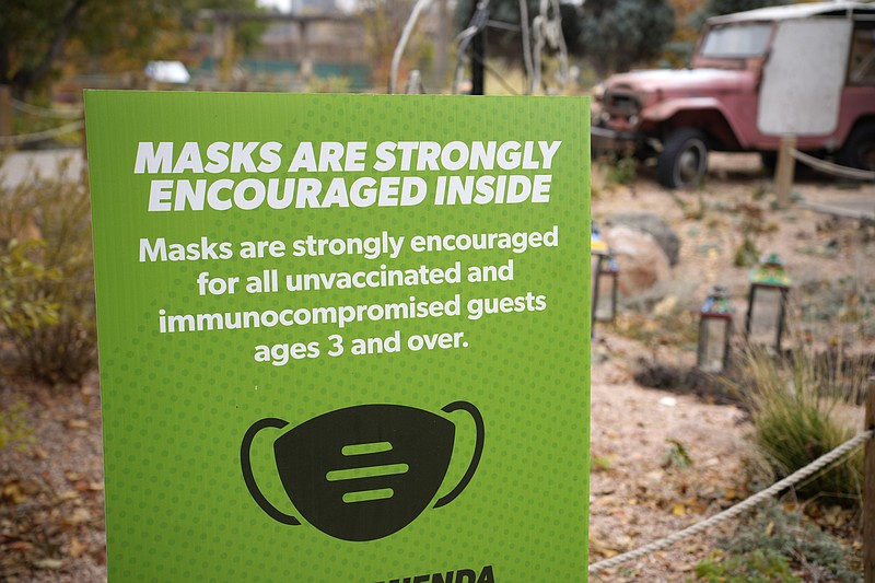 FILE - A sign encourages visitors to wear face coverings while visiting exhibits at the Denver Zoo, on Nov. 2, 2021. The U.S. is in better shape approaching its second Thanksgiving in a pandemic, thanks to vaccines, though some regions are reporting torrents of COVID-19 cases that could get even worse in the days ahead as eager families travel the country for overdue gatherings that were impossible a year ago. (AP Photo/David Zalubowski, File)