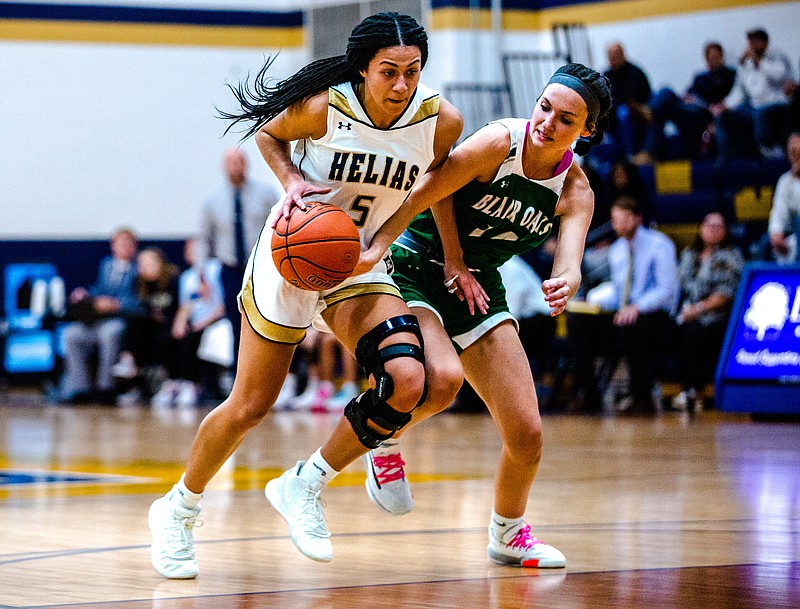 Claire Manns of Helias attempts to drive past Mallorie Fick of Blair Oaks during Tuesday night's game at Rackers Fieldhouse.