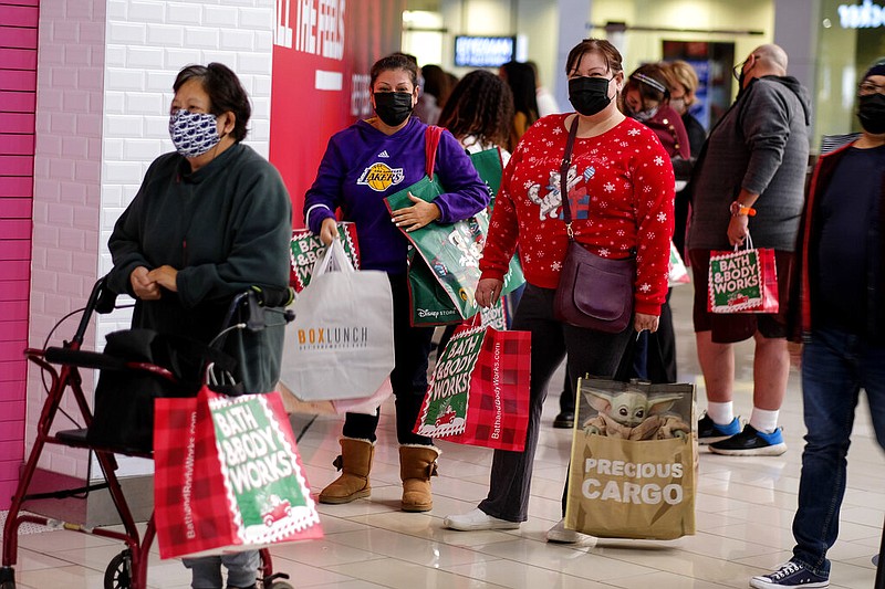 FILE - Black Friday shoppers wearing face masks wait in line to enter a store at the Glendale Galleria in Glendale, Calif., Friday, Nov. 27, 2020. 