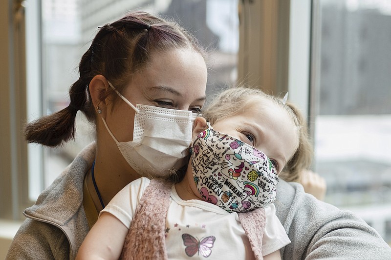 Delilah Edwards, 3, who recently underwent a heart transplant, and her mother, Samantha Davidson, embrace at Ronald McDonald House's playroom in Chicago where they planned to celebrate Thanksgiving, Wednesday morning, Nov. 24, 2021. Last month, Delilah, who was born with an underdeveloped left side of her heart, underwent 12 hours of transplant surgery. Now Delilah's parents, who live in Moline, Ill., have been staying at the Ronald McDonald House downtown while they accompany their daughter for multiple checkups each week. (Pat Nabong/Chicago Sun-Times via AP)