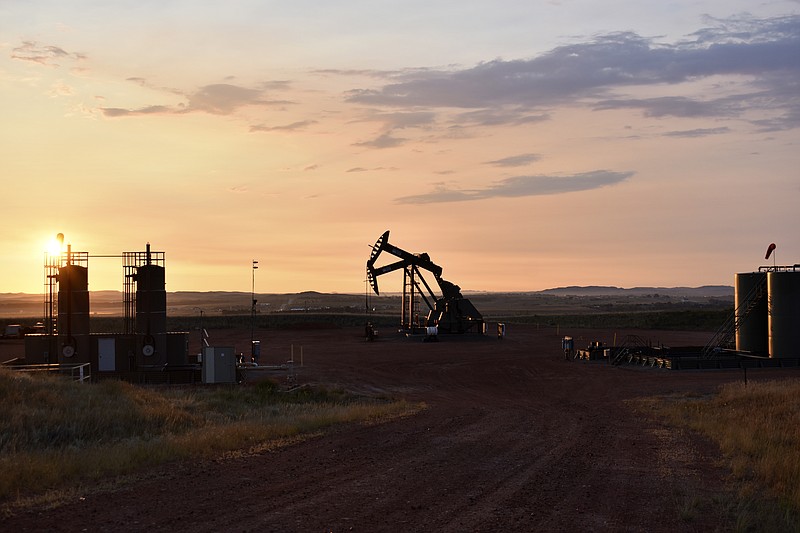 FILE - An oil well works at sunrise Aug. 25, 2021, in Watford City, N.D., part of McKenzie County. The Biden administration on Friday, Nov. 26, called for an overhaul of the nation’s oil and gas leasing program to focus on areas that are most suitable for energy development and raise costs for energy companies to drill on public lands and water.  (AP Photo/Matthew Brown, File)