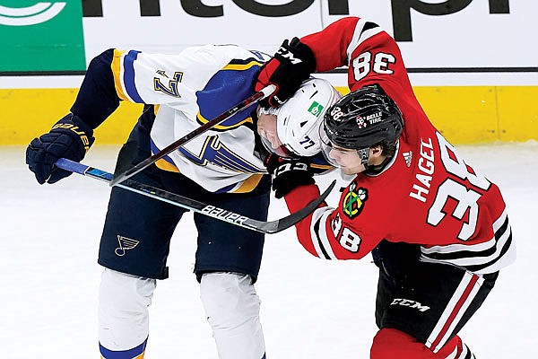 Blackhawks left wing Brandon Hage battles for the puck with Blues defenseman Niko Mikkola during the third period of Friday afternoon's game in Chicago.