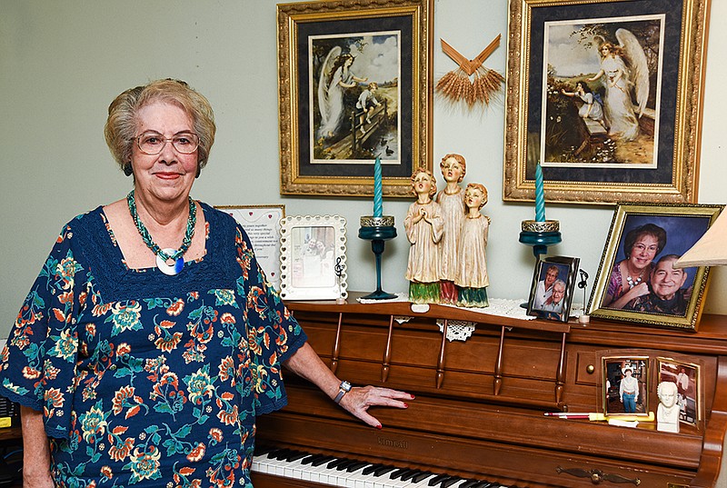 <p>Julie Smith/News Tribune</p><p>Juanita Kunzler, who has served as the principal of Immaculate Conception School and as organist at Immaculate Conception Church, poses next to the piano she purchased with money earned from her first job as a teacher.</p>