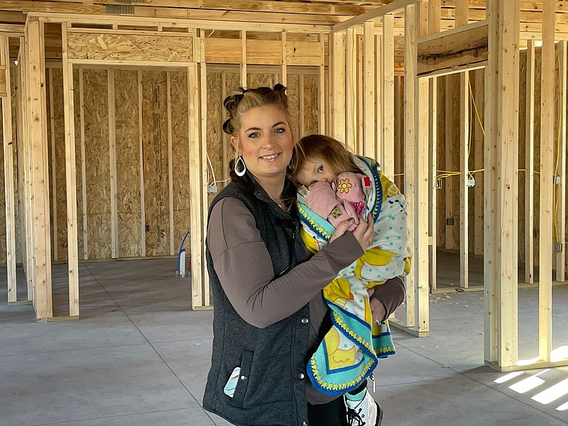 Democrat photo/Kaden Quinn Studio B Salon owner Brandy Brockes stands with her daughter, Nova, in her building currently under construction. Until the new space is finished, Studio B will remain at its current locationon South High Street.