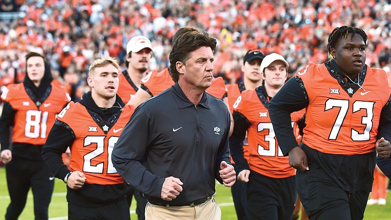 In this Oct. 30 file photo, Oklahoma State coach Mike Gundy takes the field for the team's game against Kansas in Stillwater, Okla. Oklahoma State plays Baylor today in the Big 12 Conference championship game.