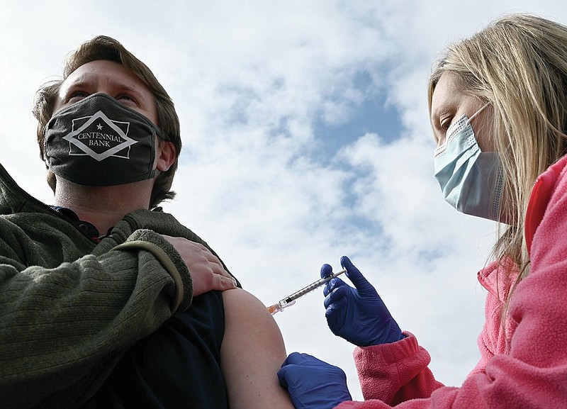 Luke Ballard, left, receives his first dose of the Pfizer vaccine from Kelly Hovorka, RN, during a public walk-up COVID-19 vaccination clinic at the Excel Center Goodwill Industries of Arkansas Campus in Little Rock on Friday, March 19, 2021. The event, which ran from 9am-4pm, administered over 300 vaccines in the first two and a half hours alone. (Arkansas Democrat-Gazette/Stephen Swofford)