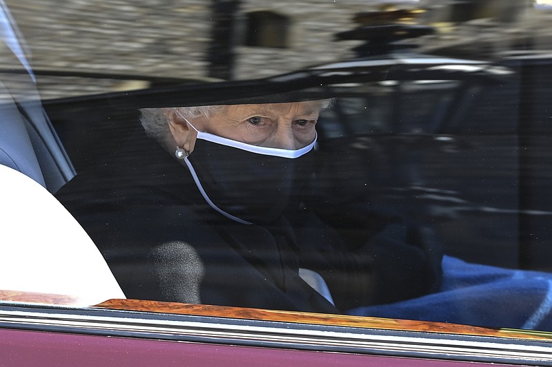 Britain's Queen Elizabeth II follows the coffin in a car as it makes it's way past the Round Tower during the funeral of Britain's Prince Philip inside Windsor Castle in Windsor, England Saturday April 17, 2021. (Leon Neal/Pool via AP)