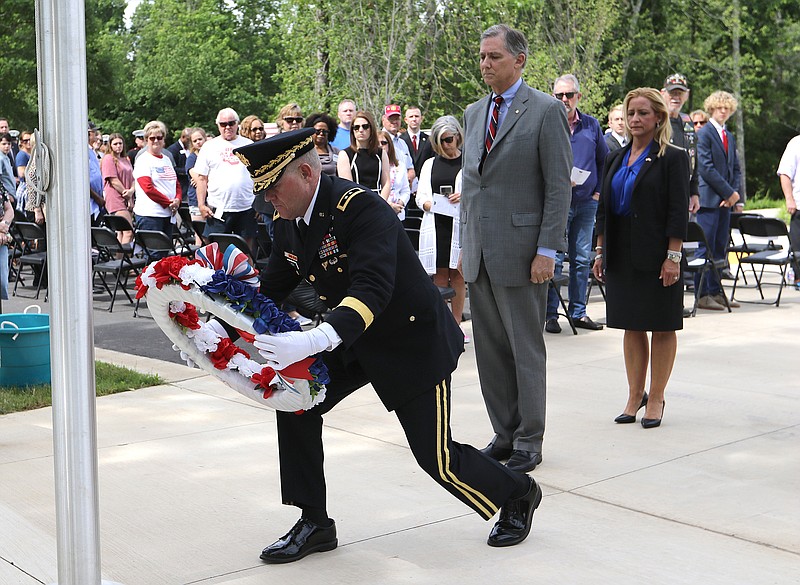 Maj. Gen Kendall Penn (left) lays a wreath at the flag pole as U.S. Rep. French Hill (center) and Arkansas Attorney General Leslie Rutledge (right) look on during the State Memorial Day Program on Monday, May 31, 2021, at the Arkansas State Veterans Cemetery in North Little Rock. (Arkansas Democrat-Gazette/Thomas Metthe)