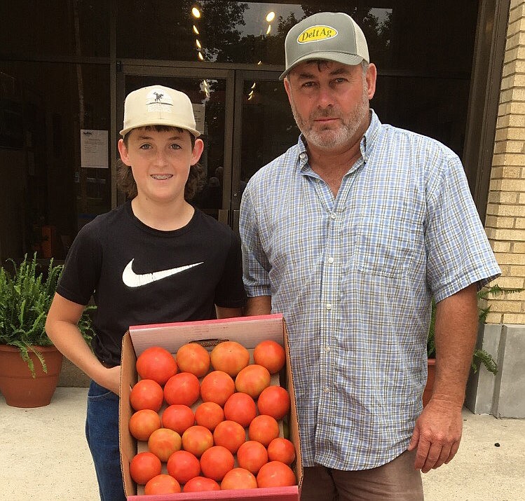 River Grice, a fifth generation farmer at Warren, brought in the first box of tomatoes for 2021 to the Bradley County Cooperative Extension Service Office. River is pictured with his father, Lynn Grice. (Special to The Commercial/John Gavin, University of Arkansas System Division of Agriculture)