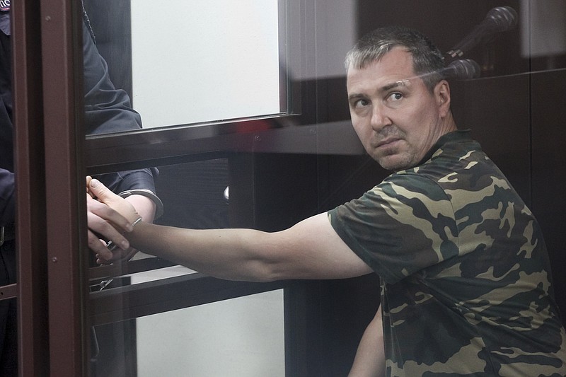 Alexander Popov, a man who was arrested on suspicion of murder sits behind the glass in a courtroom in the city of Gorodets, 36 miles north-west of Nizhny Novgorod, Russia, Sunday, June 20, 2021. A court in central Russia has arraigned the suspect on murder charges in the death of an American woman studying at a local university. The body of 34-year-old Catherine Serou was found Saturday in the woods area near the city of Nizhny Novgorod, 250 miles east of Moscow. (AP Photo/Roman Yarovitsyn)