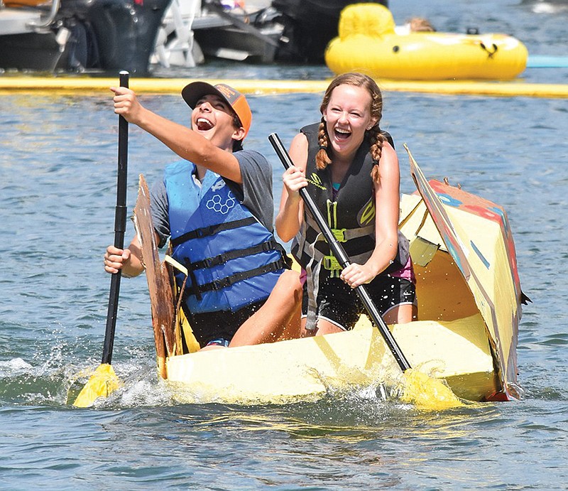 Shayne Coffey, left, and Becca Wehrung laugh as they try to close the gap between their boat and their competition at the 2019 World Championship Cardboard Boat Races in Heber Springs. This year, the boat races and the annual Fireworks Extravaganza will be combined into one event, the first Freedom Fest on the Lake, presented by the Heber Springs Area Chamber of Commerce.