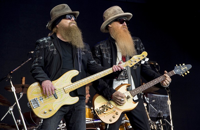 FILE - Dusty Hill, left, and Billy Gibbons from U.S rock band ZZ Top perform at the Glastonbury music festival in Somerset, England, June 24, 2016. ZZ Top has announced that Hill, one of the Texas blues trio's bearded figures and bassist, has died at his Houston home. He was 72. In a Facebook post, bandmates Billy Gibbons and Frank Beard revealed Wednesday, July 29, 2021, that Hill had died in his sleep. (Photo by Jonathan Short/Invision/AP, File)