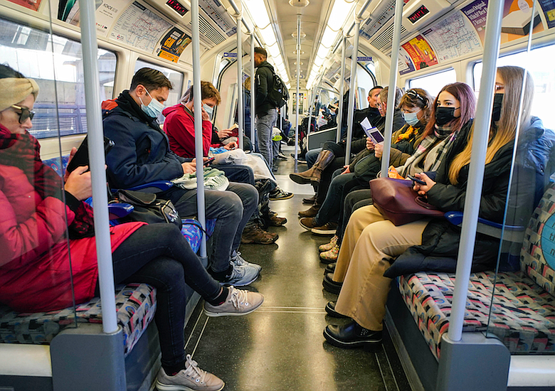 People wear face covering as they travel on the Underground, in London, Sunday, Nov. 28, 2021. Britain's Prime Minister Boris Johnson said it was necessary to take &#x201c;targeted and precautionary measures&#x201d; after two people tested positive for the new variant in England. He also said mask-wearing in shops and on public transport will be required. (AP Photo/Alberto Pezzali)