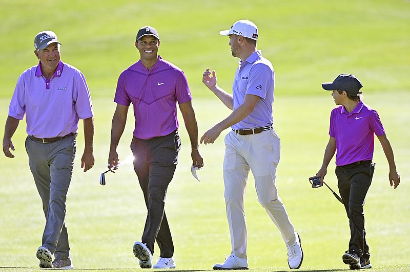 In this Dec. 19. 2020, file photo, Tiger Woods (second from left) and his son Charlie (right) walk with Justin Thomas (second from right) and his father Mike Thomas on the third fairway during the first round of the PNC Championship in Orlando, Fla. (Associated Press)