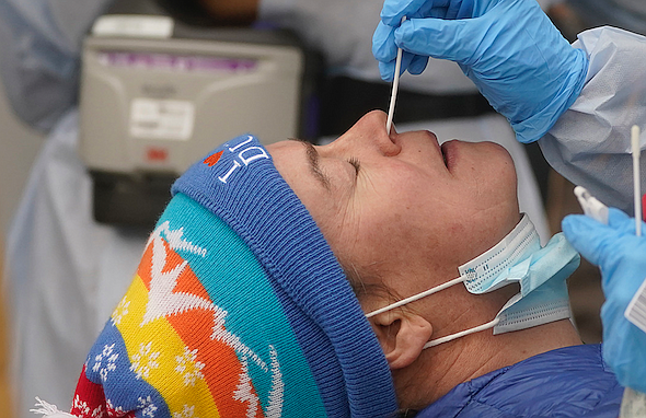 A member of the Salt Lake County Health Department COVID-19 testing staff performs a test on Chrissy Nichols outside the Salt Lake County Health Department Tuesday, Jan. 4, 2022, in Salt Lake City. (AP Photo/Rick Bowmer)