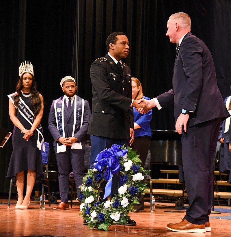 Miss LU J'hane Brown, left, and Mr. LU Austin Branch, look on as Lincoln University President John Moseley, right, shakes hands with ROTC Cadet Keon Woodall after they both placed the wreath on the stage during LU's annual Founders' Day celebration in Mitchell Auditorium. The annual event featured a keynote address by 1970 alum Carmen Fields and recognition of the Lewis Family as Family of the Year.