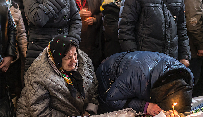 Relatives grieve at the funeral of two local soldiers killed when Russian jets bombed a military airfield in Lutsk, a city in northwest Ukraine, on Saturday, March 12, 2022. The attacks here and in Ivano-Frankivsk have pierced the relative sense of security in Western Ukraine, which has been a haven for millions fleeing the Russian invasion, as well as a corridor for relief efforts and weapons. (Brendan Hoffman/The New York Times)