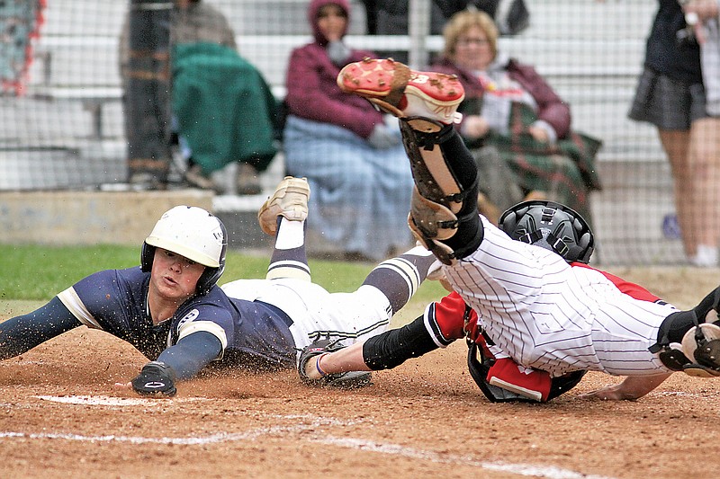 Sam Wyrick of Helias slides into home plate safely around the tag by Jefferson City catcher Will Berendzen during the sixth inning of Tuesday’s game at Vivion Field. (Greg Jackson/News Tribune)