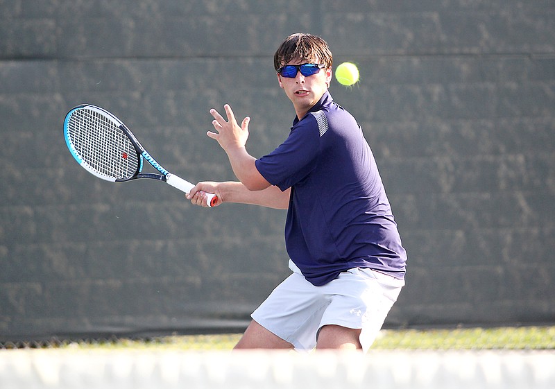 Caleb Mueller of Helias watches the ball before hitting a shot during his singles match against Capital City in the Class 2 District 5 Tournament championship dual last Wednesday at the Crusader Athletic Complex. (Greg Jackson/News Tribune)