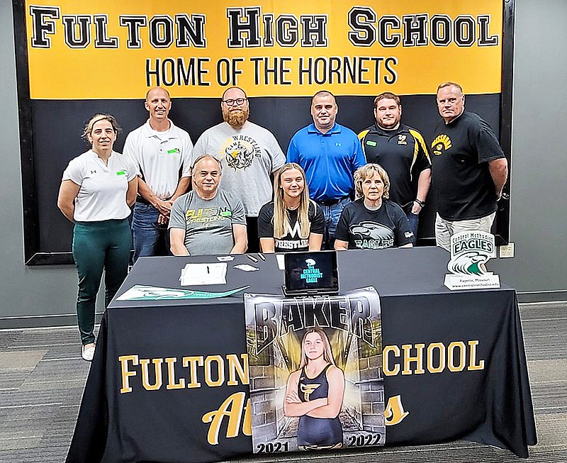 Fulton senior Rylee Baker sits at the center of the table while surrounded by her family and wrestling coaches Friday in the Fulton High School library. Baker signed to wrestle for Central Methodist University in Fayette. (Submitted)